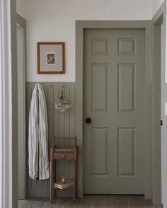 an entryway with a chair, coat rack and pictures on the wall