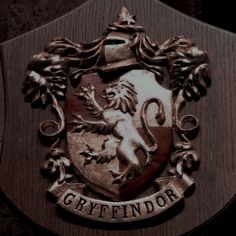 an emblem on the side of a wooden plaque that reads, orfffindor