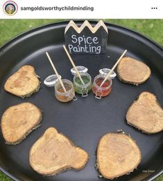 there are several slices of wood on the grill with dipping sauces in them and two small cups