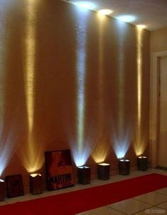 some lights that are on the side of a wall in front of a red carpet