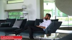 a man sitting on top of a couch in a living room