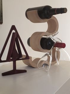 two wine glasses are sitting on a stand next to a bottle of wine and a glass holder