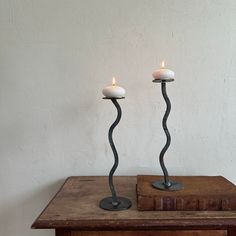 two candles sitting on top of a wooden table