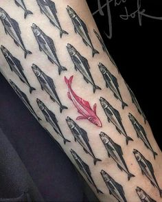 a person with a red fish tattoo on their arm