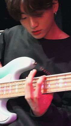 a young man is playing an electric guitar