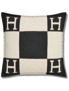 a black and white pillow with the letter h on it