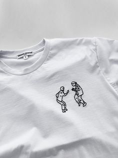 a white t - shirt with a drawing of two people on it's chest