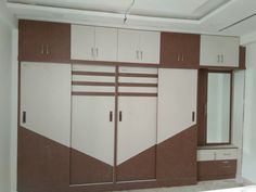 an empty room with white and brown cupboards