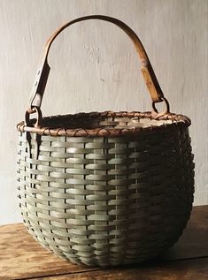 a woven basket sitting on top of a wooden table