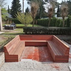 a wooden bench sitting in the middle of a yard next to a brick fire pit