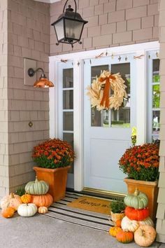 pumpkins and gourds are on the front porch