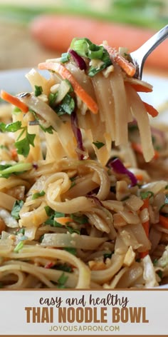 a fork full of noodles with carrots and celery