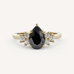 a black and white diamond ring with three stones on the side, set in yellow gold