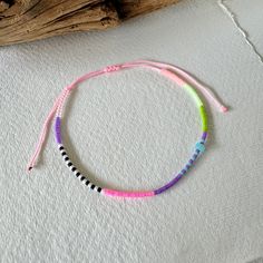 - Dive into the vibrant joy of summer with our artisanal baby pink corded anklet, a piece that encapsulates the essence of beach vibes and festival euphoria. Each anklet is meticulously handcrafted, featuring an enchanting array of Miyuki beads in shades of purple, clear, black, white, neon pink, blue, green, and salmon, crowned with a blue rondelle shell charm that whispers the secrets of the ocean. - Adjustable for comfort, this anklet promises a perfect fit for every adventurer. Its joyful pa Beach Festival, Blue Shell, Festival Jewelry, Miyuki Beads, Anklet Jewelry, Body Jewellery, Shades Of Purple, Neon Pink, Baby Pink