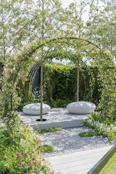 an outdoor garden with white stones and trees