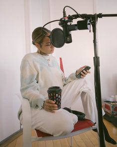 a woman sitting in a chair holding a coffee cup