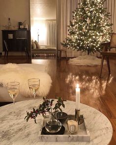 an instagram photo with a christmas tree in the background and candles on a coffee table