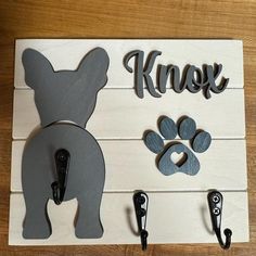 a dog leash holder with two hooks on it and an animal's paw next to it