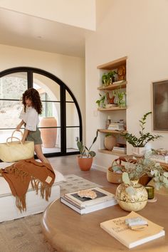 a woman sitting on top of a couch in a living room next to a window