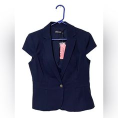 Size 6 Navy Blue Jacket. Has A Notched Collar, Front Flap Pockets, Lined, And Has Slimmed Shoulder Pads. Versatile And Designed To Move With You. Seasonless Fabric Tailored Jacket. Measurements Are: W - 16.5 In, L - 21 In, Sleeve Opening L - 5 In. Fitted Short Sleeve Blazer With Button Closure, Office Short Sleeve Blazer With Button Closure, Fitted Short Sleeve Blazer With Buttons, Short Sleeve Blazer With Button Closure For Work, Short Sleeve Outerwear With Buttons For Work, Short Sleeve Fall Blazer For Workwear, Fall Short Sleeve Blazer With Button Closure, Short Sleeve Blazer For Office In Fall, Casual Short Sleeve Blazer With Button Closure