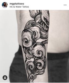 a man's arm with black and white ink on it, which has swirls in