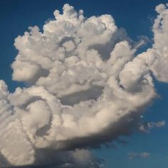 a large cloud is in the sky with some clouds behind it and blue skies above