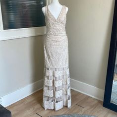 a white dress is on display in front of a mirror with a black and gray rug