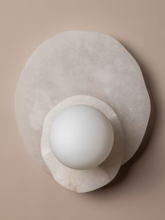 an egg sitting on top of a white plate with a light bulb in the middle