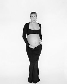 a pregnant woman poses for a black and white photo