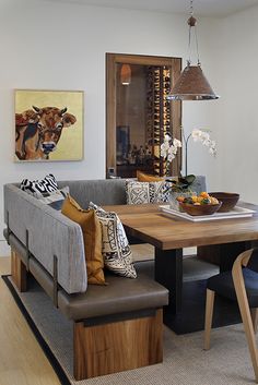 a living room with a couch, table and chairs next to a painting on the wall