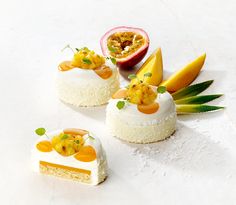 three desserts are arranged on a white surface with fruit and pineapple in the background