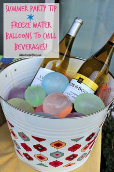 a bucket filled with bottles of wine and soaps next to a sign that says summer party tip freeze water balloons to chill beverage