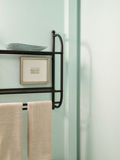 a towel rack with two towels hanging from it's sides in a bathroom next to a toilet