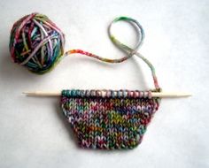 a ball of yarn next to a knitting needle