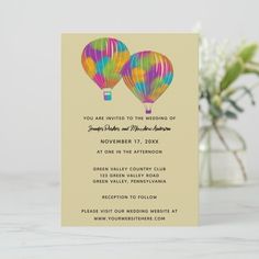 a wedding card with two hot air balloons on the front, and a couple of flowers in the back