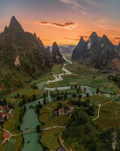 an aerial view of a valley with mountains in the background and water running through it