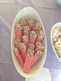 two bowls filled with sprinkles and marshmallows next to each other