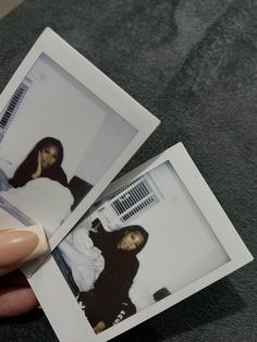 two polaroid photos being held up by someone's hand with nail polish on them