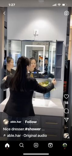 a woman is taking a selfie in front of a mirror while another person looks at her reflection