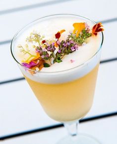 a drink with flowers in it sitting on a table