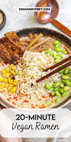 a bowl filled with noodles and vegetables next to chopsticks