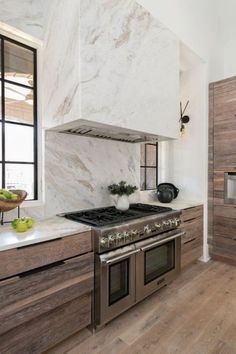 a stove top oven sitting inside of a kitchen next to wooden cabinets and counter tops