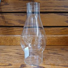 a clear vase sitting on top of a wooden table