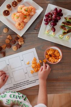 a young child is making snacks on the table