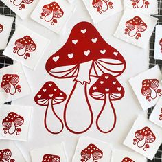 red mushrooms with hearts on them are surrounded by white squares and paper cut outs in the shape of hearts