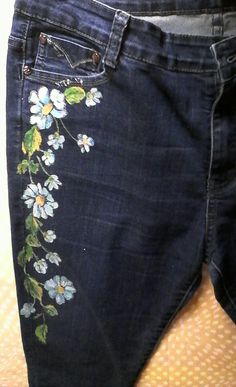 a pair of jeans with flowers painted on them