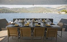 a table set up on the deck of a boat with mountains in the back ground