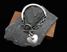 Silver Cuff Bracelet, Heart Charm Bracelet, Silver Heart Bracelet, Silver Heart Charm Bracelet, Silver Toggle Clasp Bracelet, Gift For Her Silver cuff bangle  The Chain is made from stainless steel,  The rest of the bracelet is zamak. Toggle clasp fastening and heart charm. Its  antique silver in colour which is a vintage aged tone, not a bright shiny silver. The bracelet is solid so has a good weight to it. Crafted from a zinc and brass alloy and plated in antique silver which is both hardweari Metal Heart Bracelet With Toggle Clasp, Valentine's Day Gift Bracelet With Toggle Clasp, Heart Shaped Bracelet With Toggle Clasp As Gift, Heart-shaped Charm Bracelet With Toggle Clasp As Gift, Heart Charm Bracelet With Toggle Clasp For Gift, Silver Heart Bracelet With Toggle Clasp, Heart Shaped Toggle Clasp Bracelet For Gift, Silver Heart-shaped Bracelet With Toggle Clasp, Valentine's Day Heart Bracelet With Toggle Clasp