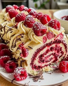 a cake with raspberries and cream frosting on a plate next to some berries