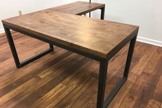 two wooden tables sitting on top of a hard wood floor next to a white wall